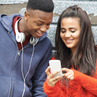 Two teens looking at a mobile phone